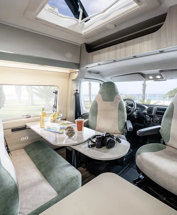 Familie kocht und lacht gemeinsam im Wohnmobil.